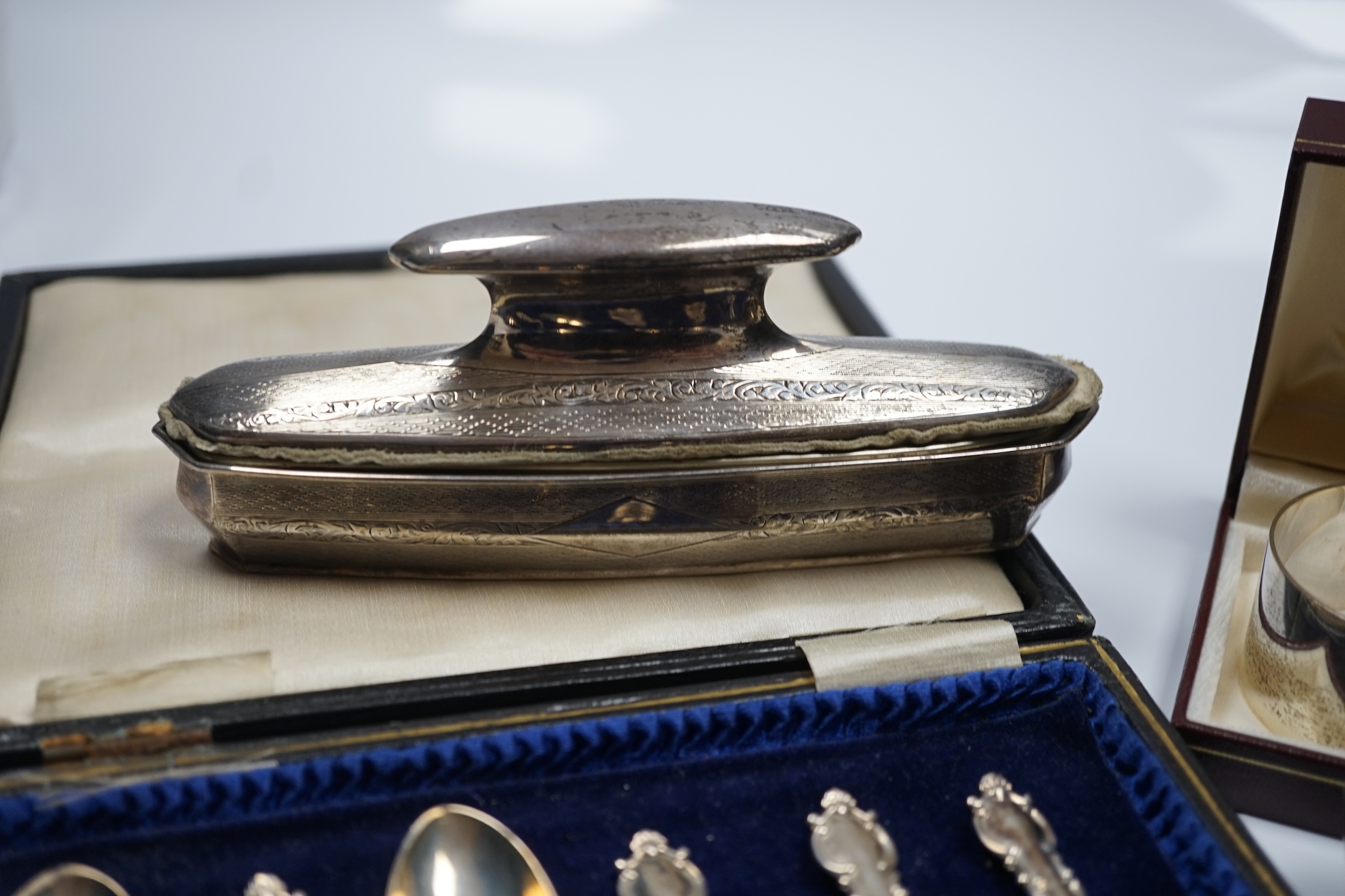A George V engraved silver mounted nail buffer with cover, Birmingham, 1928, 14.9cm, together with a silver cigarette case, a silver napkin ring and a cased set of six silver teaspoons.
